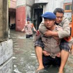 Brimob Polda Metro Jaya Gendong Warga Sakit Terjebak Banjir di Cengkareng, Jakarta Barat