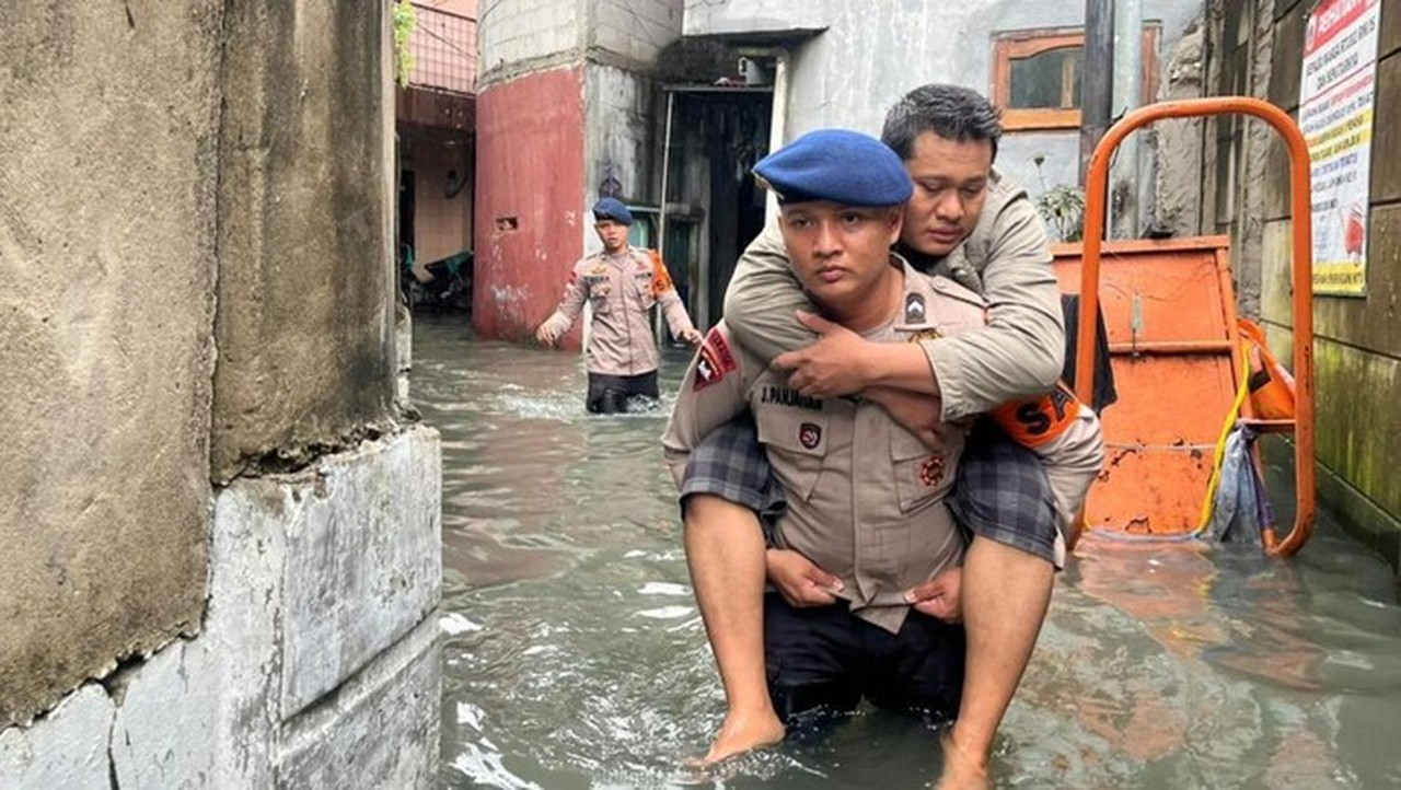 Brimob Polda Metro Jaya Gendong Warga Sakit Terjebak Banjir di Cengkareng, Jakarta Barat
